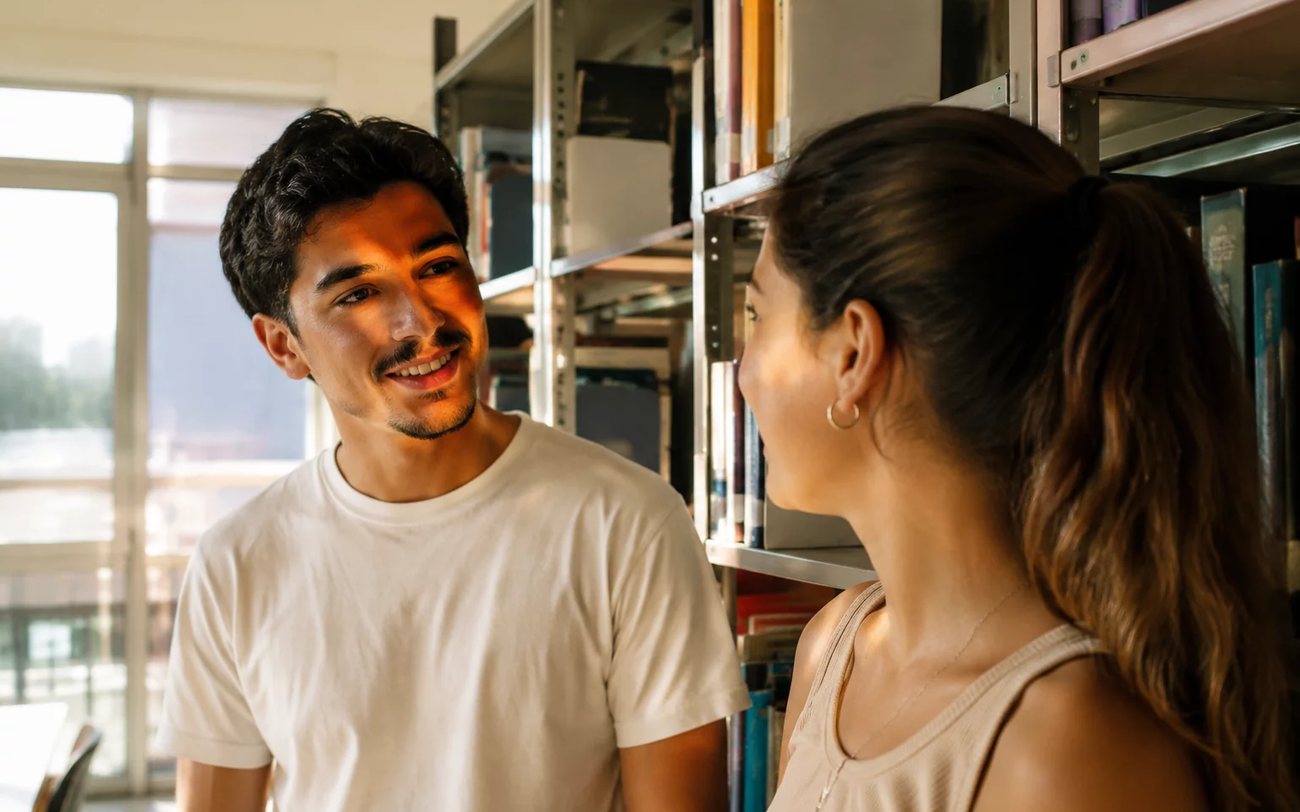 Conversa em andamento numa mesa comprida de sala clara, com três pessoas atentas ao que se fala